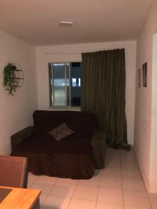 un salon avec un canapé et une fenêtre dans l'établissement Loft House kalleb, à Aracaju