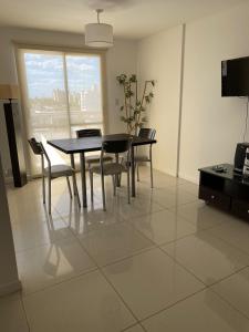 a dining room with a black table and chairs at Dpto 9 DE JULIO in Villa María