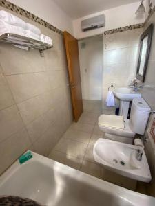 a bathroom with a sink and a tub and a toilet at Dpto 9 DE JULIO in Villa María +6 photos