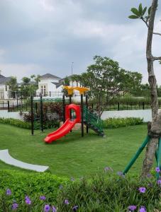 a playground with a red slide in a park at entire house for you in Cikeas