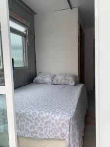 a bedroom with a bed in a room with a window at Vila do Chaves Casa da Popis 23 in Itajaí