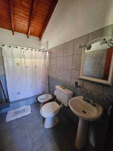 un bagno con due wc, un lavandino e uno specchio di Cabañas Toay Merlo San Luis a Merlo Altre 90 foto