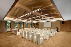 une salle de conférence avec des chaises blanches et un podium dans l'établissement Wonderland Resort, Hangzhou Jiande, A Tribute Portfolio Resort, à Qiantan