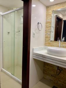 a bathroom with a sink and a glass shower at Apartamento Vista Praia do Anil in Angra dos Reis