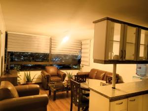 a living room with a couch and chairs and a table at Acogedor Departamento in Iquique