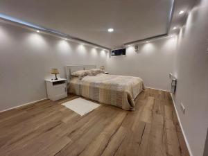 a bedroom with a bed and a wooden floor at Charmant appartement moderne à Trouville in Trouville-sur-Mer +4 photos