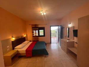 a bedroom with a bed and a television in it at Sissy's Suites San Antonio Beach Potos Thassos in Potos