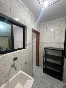 a bathroom with a sink and a window at APÊ VISTA MAR, 20mts DA PRAIA, ESPAÇOSO E ACONCHEGANTE-56m2- WIFI- 1 DORM-ELEVADOR- 6 PESSOAS in Praia Grande