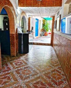 une pièce avec un sol carrelé et un mur en briques dans l'établissement Hostal Luna Llena Getsemaní, à Carthagène des Indes