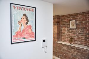 伯明翰Luxury Nostalgic City Centre Stay with Pool Table, Netflix, Sofa bed, Sleeps 6, Nostalgia Stays的一张女工在砖墙上用电话说话的海报
