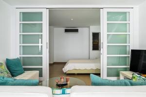 a living room with a couch and a room with a bed at Duplex de lujo in Same