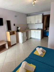 a kitchen with a blue bed in a room at Sissy's Suites San Antonio Beach Potos Thassos in Potos