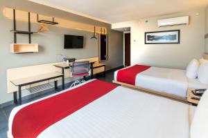 A bed or beds in a room at City Express by Marriott Tuxpan