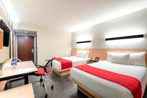 A bed or beds in a room at City Express by Marriott Tuxpan
