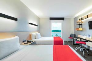 A bed or beds in a room at City Express by Marriott Tuxpan