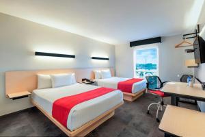 A bed or beds in a room at City Express by Marriott Tuxpan