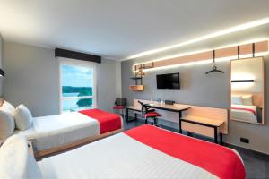 A bed or beds in a room at City Express by Marriott Tuxpan