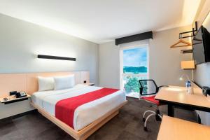 A bed or beds in a room at City Express by Marriott Tuxpan