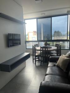 a living room with a couch and a table with chairs at Residencial ISL - Praia da Pinheira SC in Palhoça