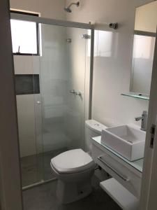 a bathroom with a toilet and a sink and a shower at Residencial ISL - Praia da Pinheira SC in Palhoça +32 photos