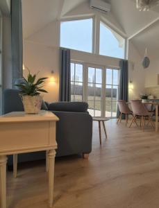a living room with a couch and a table at Káli Pillangó - Ház a völgyben in Balatonhenye