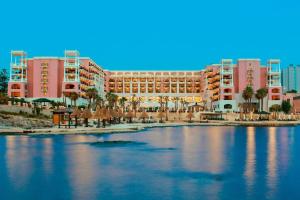a resort with palm trees and a body of water at The Westin Dragonara Resort, Malta in St. Julianʼs