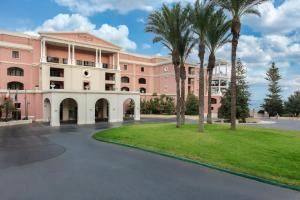 a pink building with palm trees in front of it at The Westin Dragonara Resort, Malta in St. Julianʼs