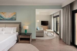 a bedroom with a bed and a living room at The Westin Dragonara Resort, Malta in St. Julianʼs