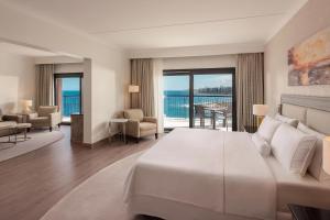 a bedroom with a large bed and a view of the ocean at The Westin Dragonara Resort, Malta in St. Julianʼs