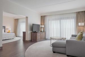 a hotel room with a bed and a couch and a tv at The Westin Dragonara Resort, Malta in St. Julianʼs