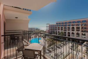 a balcony with a table and chairs on a building at The Westin Dragonara Resort, Malta in St. Julianʼs