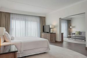 a hotel room with a bed and a television at The Westin Dragonara Resort, Malta in St. Julianʼs