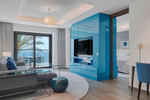 a living room with a blue cabinet with a tv at The Westin Dragonara Resort, Malta in St. Julianʼs
