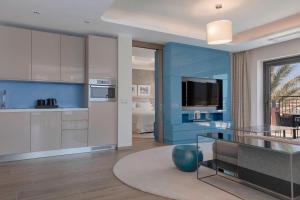 a kitchen with blue and white cabinets and a glass table at The Westin Dragonara Resort, Malta in St. Julianʼs