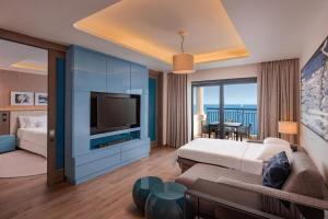 a hotel room with a bed and a television at The Westin Dragonara Resort, Malta in St. Julianʼs