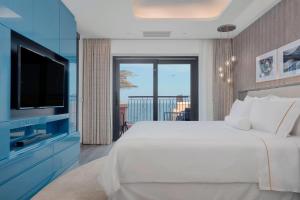 a bedroom with a large bed and a television at The Westin Dragonara Resort, Malta in St. Julianʼs