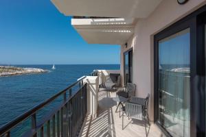 a balcony with chairs and a view of the ocean at The Westin Dragonara Resort, Malta in St. Julianʼs