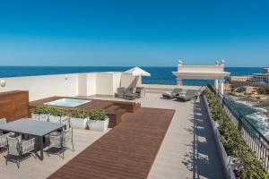 a patio with a table and chairs and the ocean at The Westin Dragonara Resort, Malta in St. Julianʼs