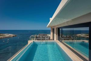 a swimming pool with a view of the ocean at The Westin Dragonara Resort, Malta in St. Julianʼs