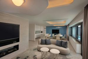 a living room with a couch and a flat screen tv at The Westin Dragonara Resort, Malta in St. Julianʼs