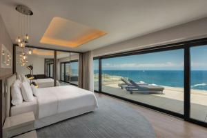 a bedroom with a bed and a view of the ocean at The Westin Dragonara Resort, Malta in St. Julianʼs