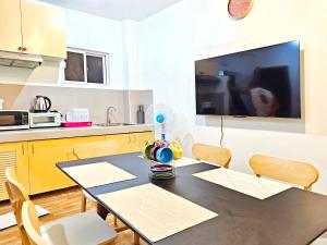 a kitchen with a table and chairs and a tv at Demit Apartment- 2br near airport - 2 in Puerto Princesa City