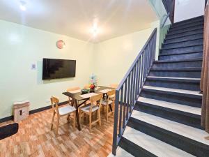 a dining room with a table and a staircase at Demit Apartment- 2br near airport - 2 in Puerto Princesa City
