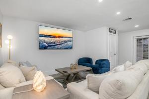 a living room with two white couches and a table at The Waterfront Fishing Retreat in Cape Coral