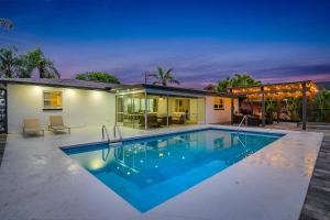 a swimming pool in front of a house at The Waterfront Fishing Retreat in Cape Coral