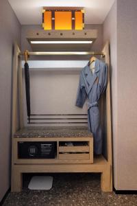 a closet with a shirt and a suit on a hanger at Arthur Hotel Canton Tower Guangzhou-广州塔骑士物语酒店 in Guangzhou