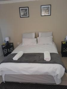 a large bed with two white towels on it at SoftLife Guest House in Ulundi