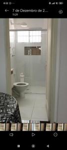 a bathroom with a toilet and a glass shower at Espaço Shalom in Praia Grande +10 photos