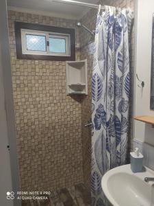 a bathroom with a shower curtain and a sink at Draco in Bella Vista