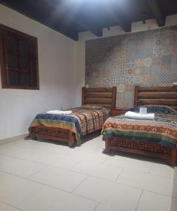 due letti uno accanto all'altro in una stanza di Hotel Arcos del Carmen a San Cristóbal de Las Casas